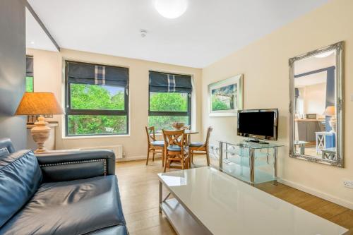 a living room with a couch and a tv at Princes Street Suites in Edinburgh
