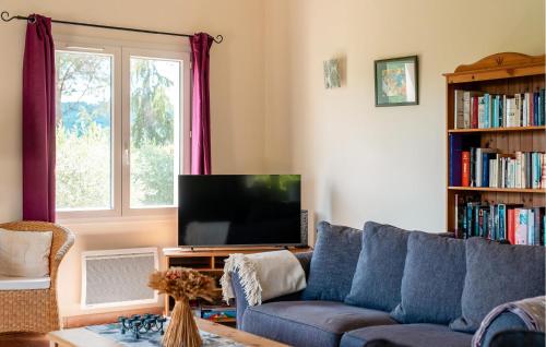 un salon avec un canapé bleu et une télévision dans l'établissement Amazing Home In Prades Sur Vernazobre, à Prades-sur-Vernazobre