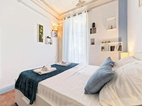une chambre blanche avec un lit avec deux serviettes dessus dans l'établissement CENTRE DE NICE- MAGNIFIQUE APPARTEMENT DE 50m2, à Nice
