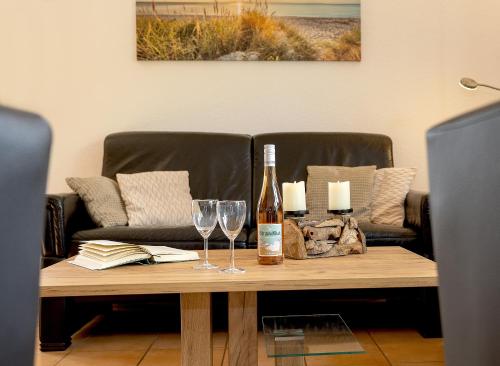 a table with a bottle of wine and two glasses at MEERerholung in Zinnowitz