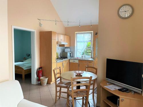 Una cocina y un comedor con una mesa y un televisor. en Gartenhaus, Mühlenstraße, en Wyk auf Föhr