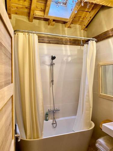une baignoire avec un rideau de douche dans une salle de bain dans l'établissement Chalet l'Atypique - 10 personnes, à Bolquère-Pyrénées 2000