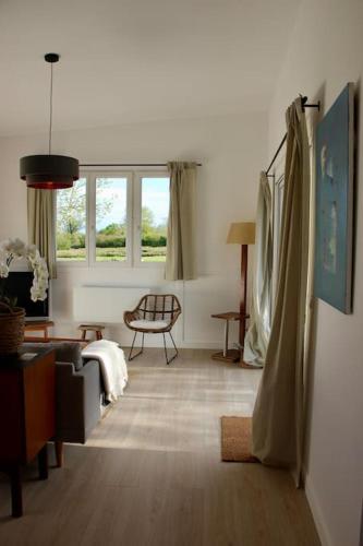 un salon avec un canapé et une chaise dans l'établissement Maison de Campagne proche plage, à Blainville-sur-Mer