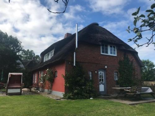 a large red brick house with a thatched roof at Midlum- Finnegan, EG in Midlum