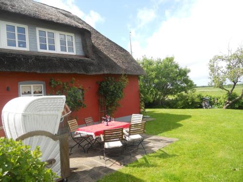 a patio with a table and chairs in front of a house at Midlum- Finnegan, EG in Midlum