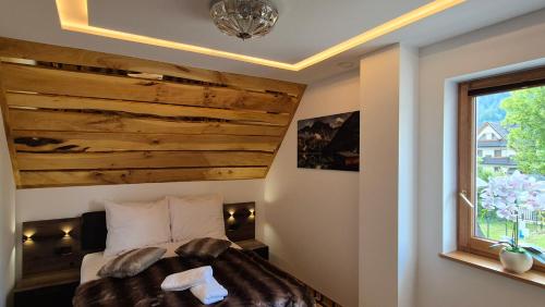 a bedroom with a bed with a wooden headboard and a window at Royal House in Zakopane