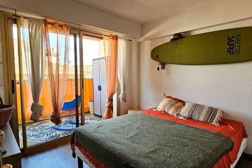 une chambre avec une planche de surf accrochée au mur dans l'établissement Appartement Cosy Centre Ville Roquebrune-Cap-Martin Carnoles, à Roquebrune-Cap-Martin