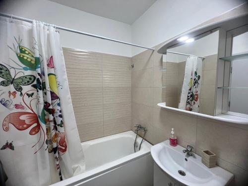 ein Badezimmer mit einer Badewanne, einem Waschbecken und einem Duschvorhang in der Unterkunft Apolonium Apartment Properties in Bukarest