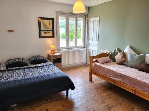 a bedroom with a bed and a couch at Maison de bord de mer, les Fleurs in Créances