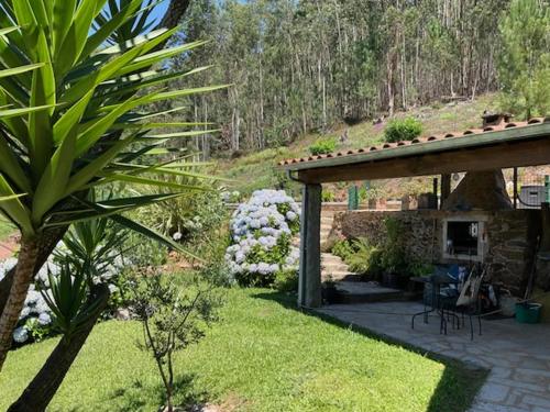 a garden with a patio and a stone building with a yard sidx sidx at Cantinho do Carmo in Fragoso