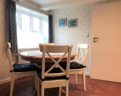 a dining room with a table and two chairs at Haus Arfsten "Deichgraf", Nieblum in Nieblum