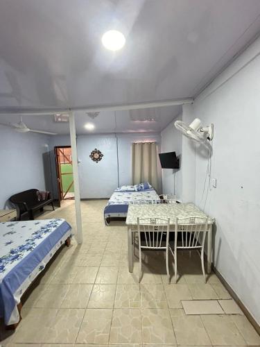 a room with two beds and a table in it at Blue Morpho House B&B in Manuel Antonio