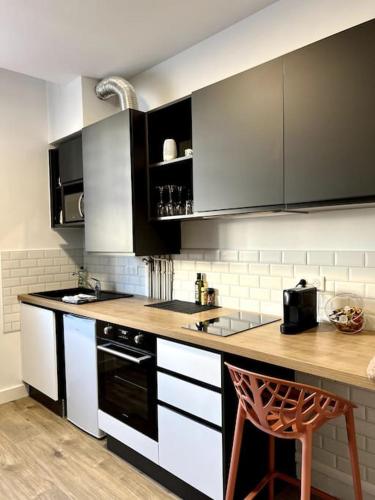 une cuisine avec des armoires en noir et blanc et un comptoir dans l'établissement NEW T2 au centre de Lorient 3min de la gare, à Lorient