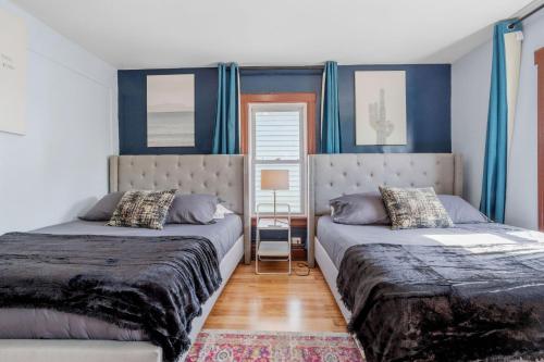 two beds in a bedroom with blue walls at 9 Bedroom, 14 Beds House Great for Big Groups Near Boardwalk, Tropicana in Atlantic City