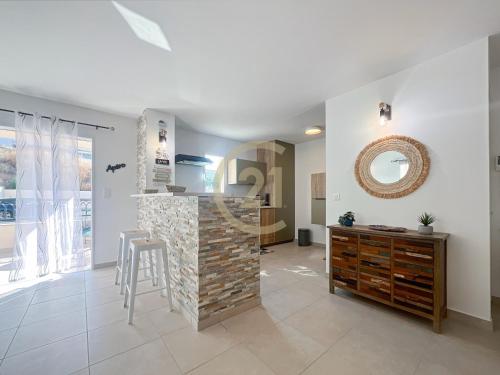 un salon avec un comptoir, une table et un miroir dans l'établissement Ile Rousse T2 proche centre-ville, à LʼÎle-Rousse