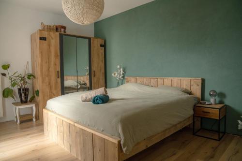 a bedroom with a large bed with a wooden headboard at Modern appartement met gratis fietsen in Breda