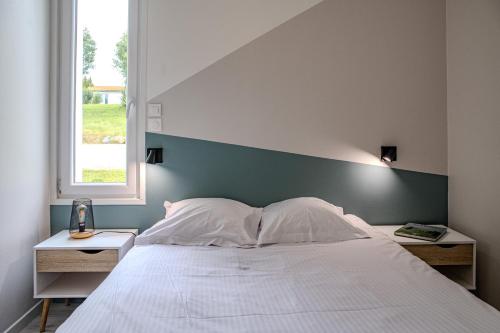 a bedroom with a large white bed and a window at Etang et Famille - Sherlock in Verruyes