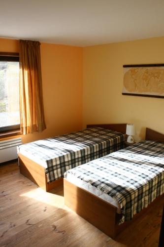 a bedroom with two beds and a window at Guesthouse KaraIvan in Arda