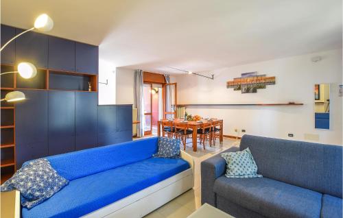 a living room with a blue couch and a table at Amazing Apartment In Lignano Sabbiadoro in Lignano Sabbiadoro