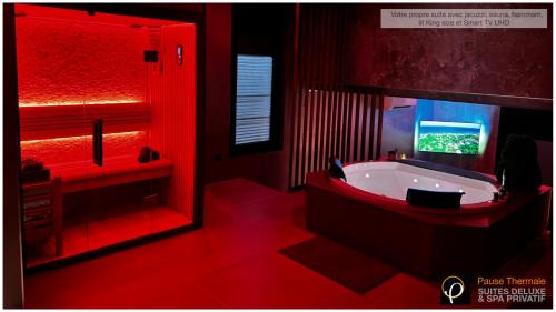 a red bathroom with a tub and a tv at Pause Thermale Suites Deluxe et Spa Privatif in Herstal