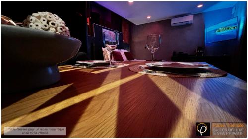 a table with two glasses of wine on it at Pause Thermale Suites Deluxe et Spa Privatif in Herstal