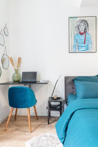 - une chambre avec un lit bleu et un bureau avec un ordinateur portable dans l'établissement New - L'Azura - Qualité Premium - Balcon en hypercentre - insonorisation maximisée, à Nantes
