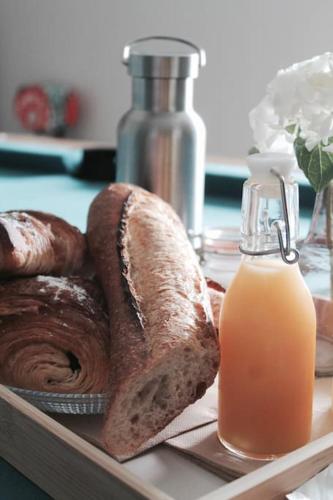 - un plateau avec du pain et une bouteille de jus d'orange dans l'établissement Jacuzzi privatisé en accès illimité Duplex, à Villedieu-les-Poêles