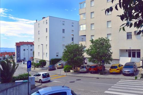a parking lot with cars parked in front of buildings at Apartment Marija in Split