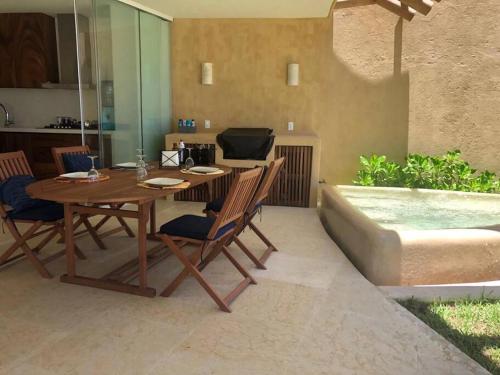 a patio with a table and chairs and a pool at Hermosa villa a pie de playa in Barra de Potosi