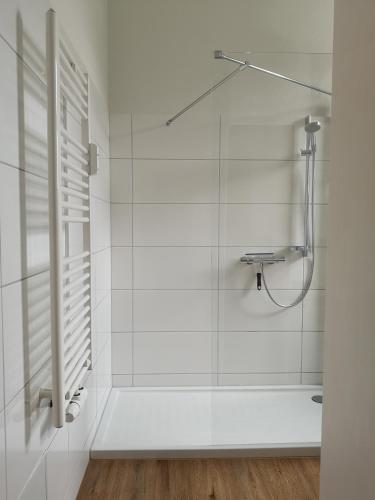 a white bathroom with a shower and a sink at "Bergliebe"-Alte Villa-2 Bäder-Eigener Parkplatz in Bad Harzburg