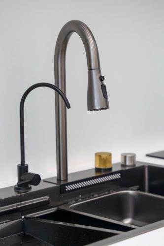 a kitchen sink with a faucet on a counter at 59 Bleu H City Center Apart with FreeParking, AC, and an extra large comfy bed in Cluj-Napoca