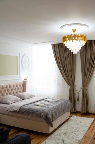 a bedroom with a large bed and a chandelier at 59 Bleu H City Center Apart with FreeParking, AC, and an extra large comfy bed in Cluj-Napoca