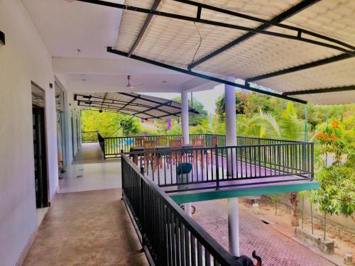 a balcony of a house with a view of a garden at Bee and Birds Hotel in Polonnaruwa
