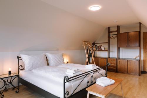 a bedroom with a large bed and a wooden floor at SCHILCHERLANDLEBEN - Kellerstöckl in Sankt Stefan ob Stainz