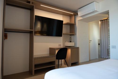 a room with a bed and a desk and a tv at Vico Concept Rooms in Termoli