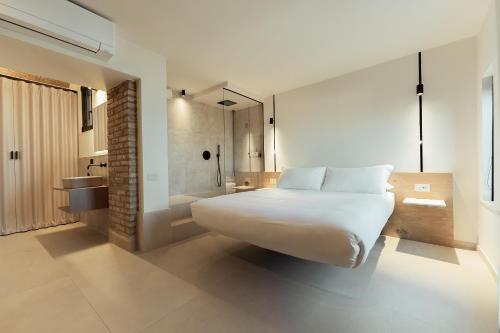 a bedroom with a large white bed and a bathroom at Vico Concept Rooms in Termoli
