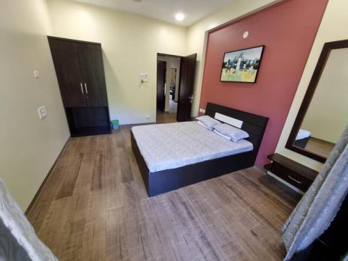 a bedroom with a bed and a red wall at Whiteville Villa in Nandgaon