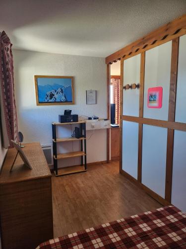 une chambre avec un bureau et une porte dans l'établissement Le Parc aux étoiles 1800, à Puy-Saint-Vincent