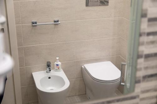a small bathroom with a toilet and a sink at Pietre Azzurre Rooms in Pachino