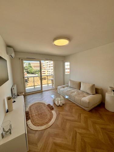 un salon avec un canapé et une table dans l'établissement Charmant 2P Moderne et Épuré Près de la Mer et de la Célèbre Promenades des Anglais - Vivez le Rêve Méditerranéen, à Nice
