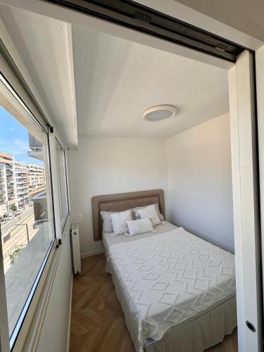 une petite chambre avec un lit et une fenêtre dans l'établissement Charmant 2P Moderne et Épuré Près de la Mer et de la Célèbre Promenades des Anglais - Vivez le Rêve Méditerranéen, à Nice
