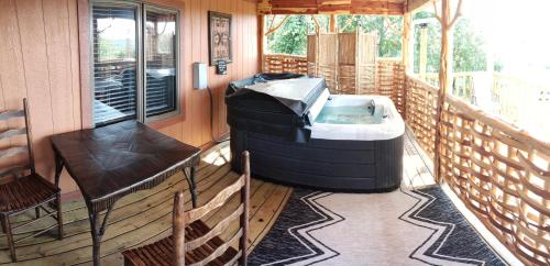 Un jacuzzi en un porche con una mesa y una silla. en Cedar House, en Rockaway Beach