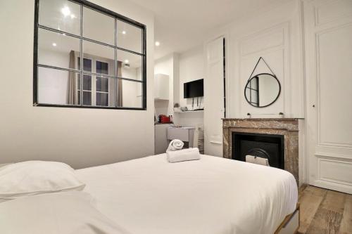 une chambre blanche avec un lit et une cheminée dans l'établissement Le Petit Condé - Fully equipped studio - Lyon 2nd, à Lyon