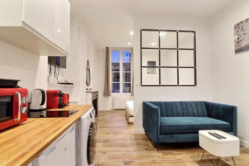 un salon avec un canapé bleu dans une cuisine dans l'établissement Le Petit Condé - Fully equipped studio - Lyon 2nd, à Lyon