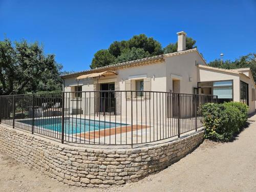 une clôture en face d'une maison avec piscine dans l'établissement Comme un Dimanche, piscine privée avec jardin, à Joucas