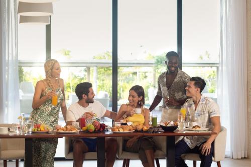 un gruppo di persone seduti intorno a un tavolo con cibo di Live Aqua Punta Cana - All Inclusive - Adults Only a Punta Cana