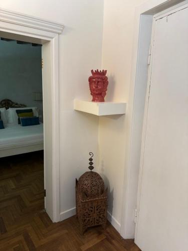 a room with a white wall with a red vase on a shelf at Hotel Torino in Venice