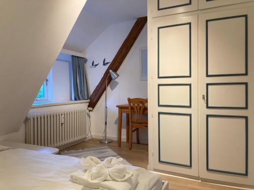 a bedroom with a door with towels on a bed at Heuboden, Nieblum in Nieblum
