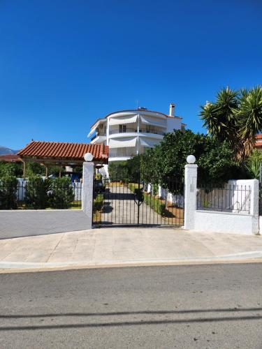 a white fence in front of a house at Garden House in Amarinthos