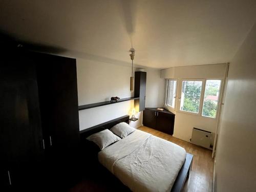 une chambre avec un lit blanc et une fenêtre dans l'établissement -N7 Appartement- 6 min to metro, à Villejuif